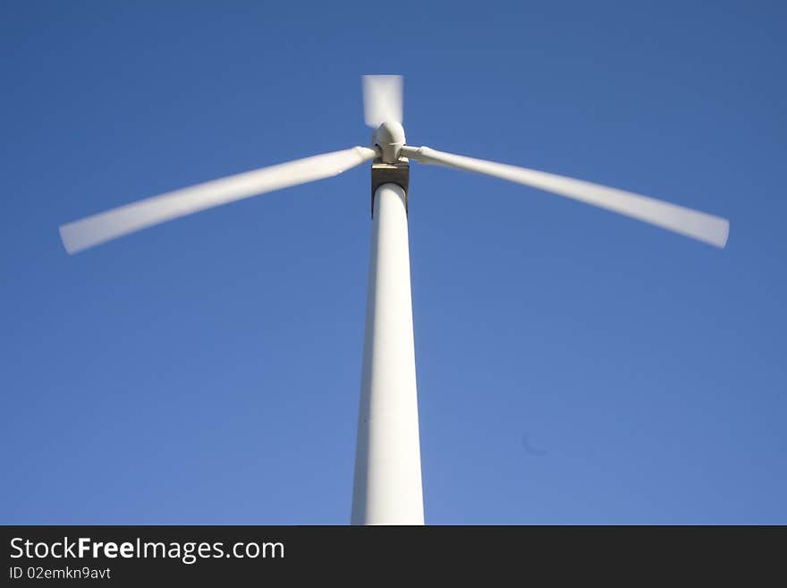 Wind turbine isolated over a blue sky. Alternative energy source