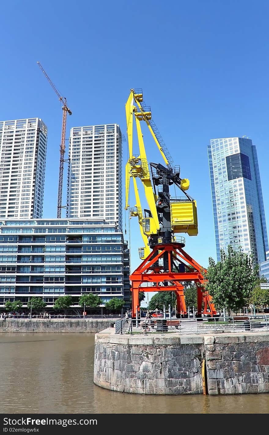 Old crane in a modern city harbor.