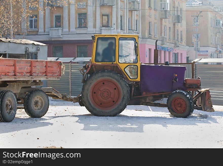 The heavy building bulldozer working on snow