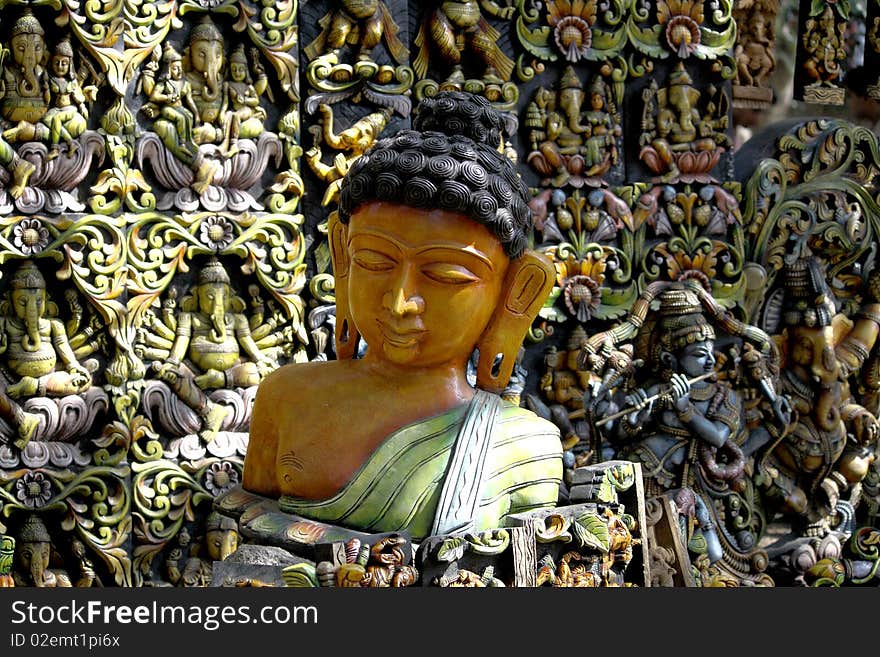 A sculpture of buddha against a background full of idols