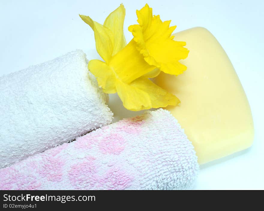 Two towels, soap and yellow flower at the white background. Two towels, soap and yellow flower at the white background