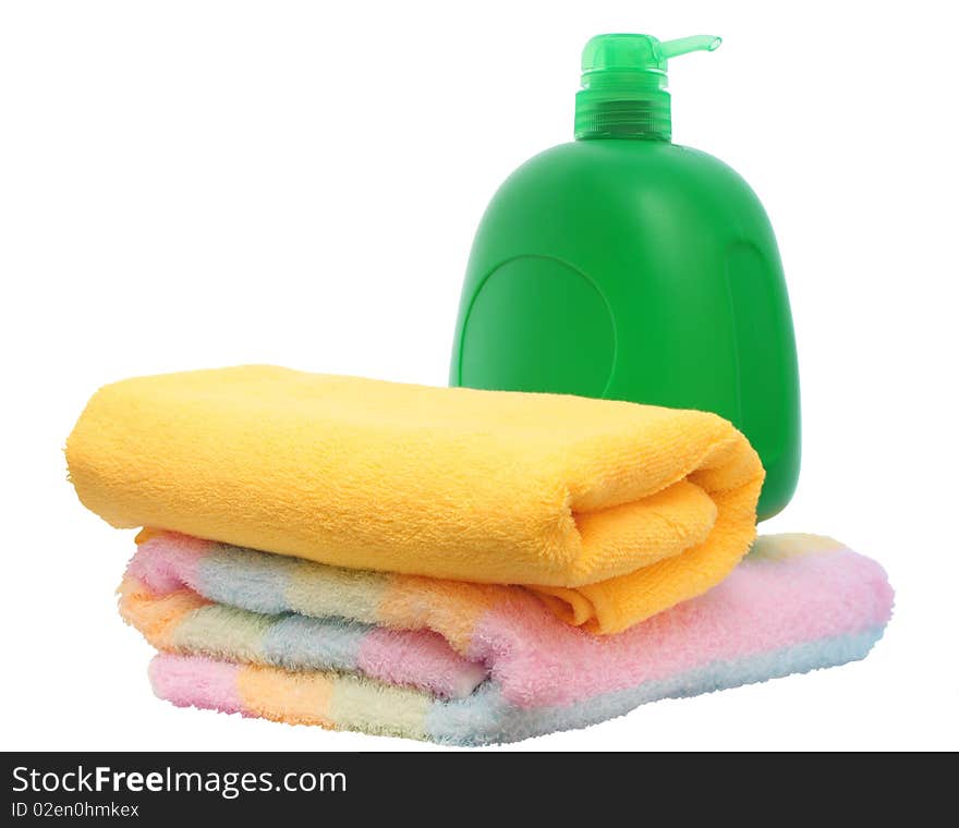 Green plastic bottle and two colour towels on white background. Green plastic bottle and two colour towels on white background.