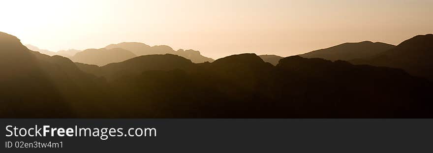 Panorama of the sun setting over misty mountains. Panorama of the sun setting over misty mountains