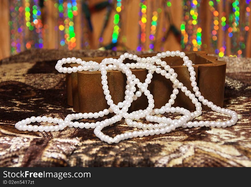 White pearl necklace in a box on an abstract background