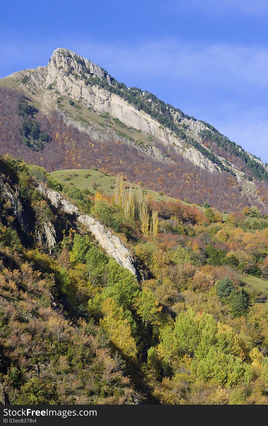 Autumnal forest and rocky peak in the Pyrenees, Spain