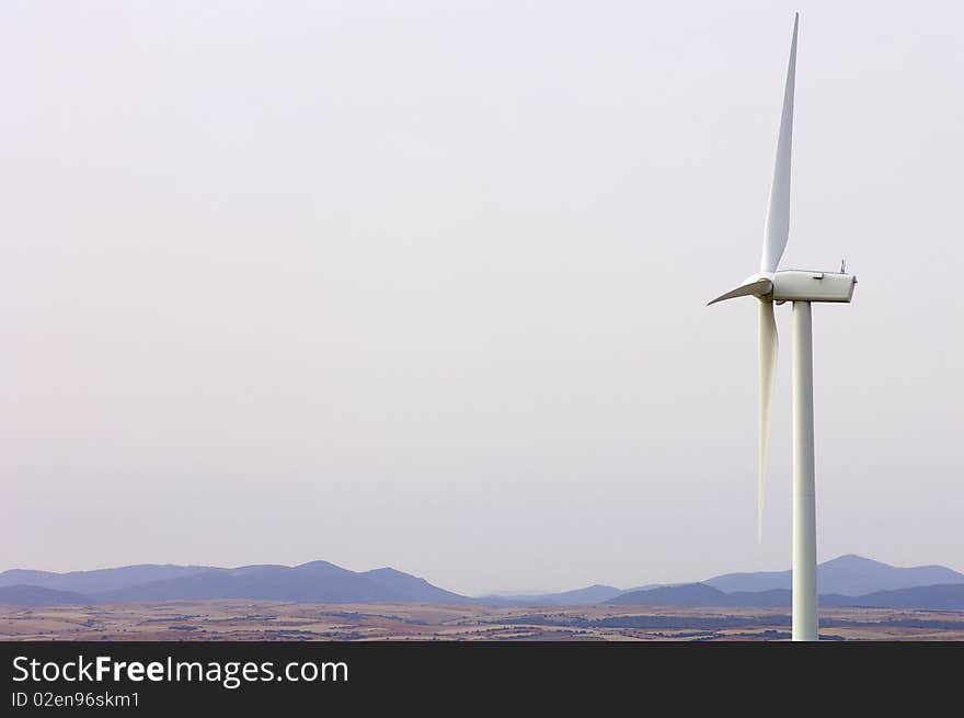 Lone windmill with a white sky in a dry landscape. Lone windmill with a white sky in a dry landscape