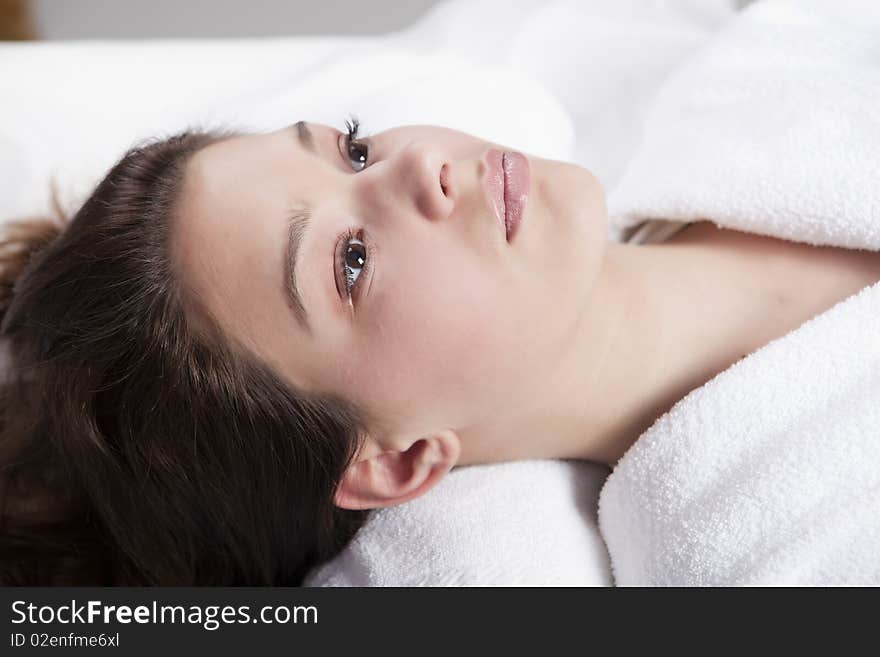 Beautiful young women in the spa, looking at camera, brunette, wearing white towel robe. Beautiful young women in the spa, looking at camera, brunette, wearing white towel robe.