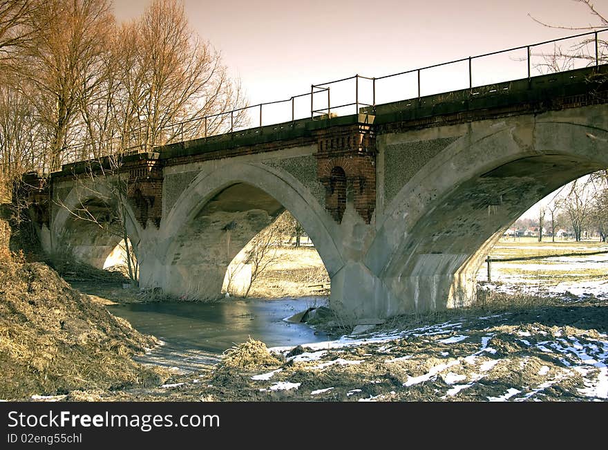 Old stone bridge with three arches of passage.