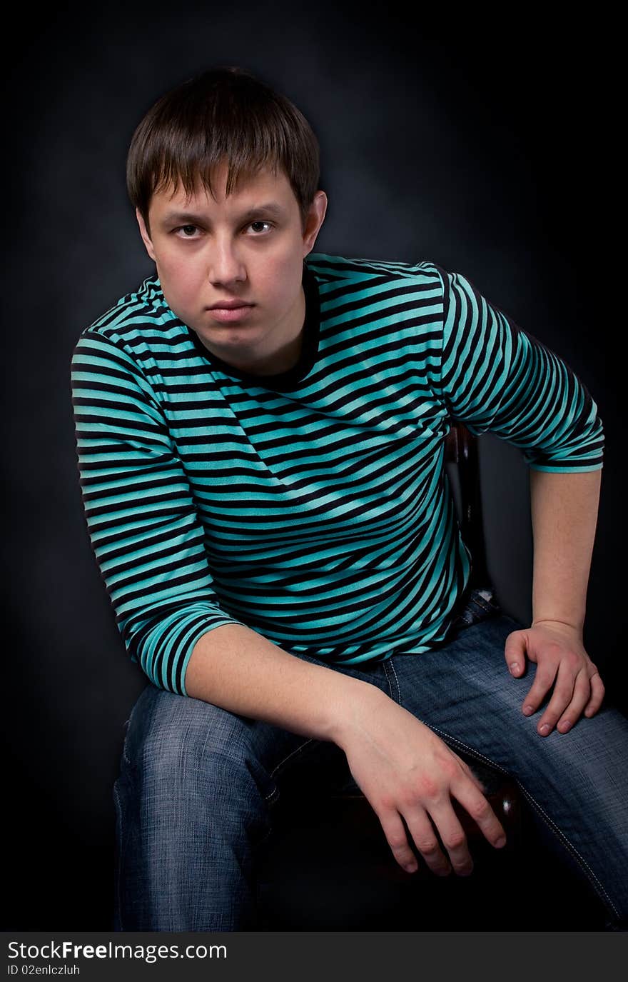 The young man sitting on a chair. The young man sitting on a chair