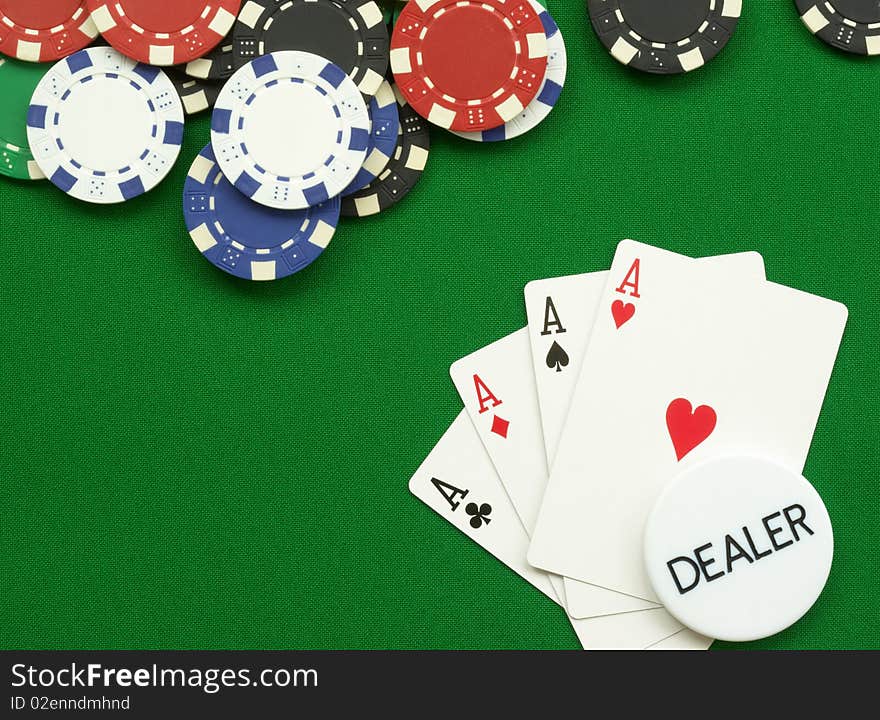 Poker hand four aces with chips and dealer button on green felt