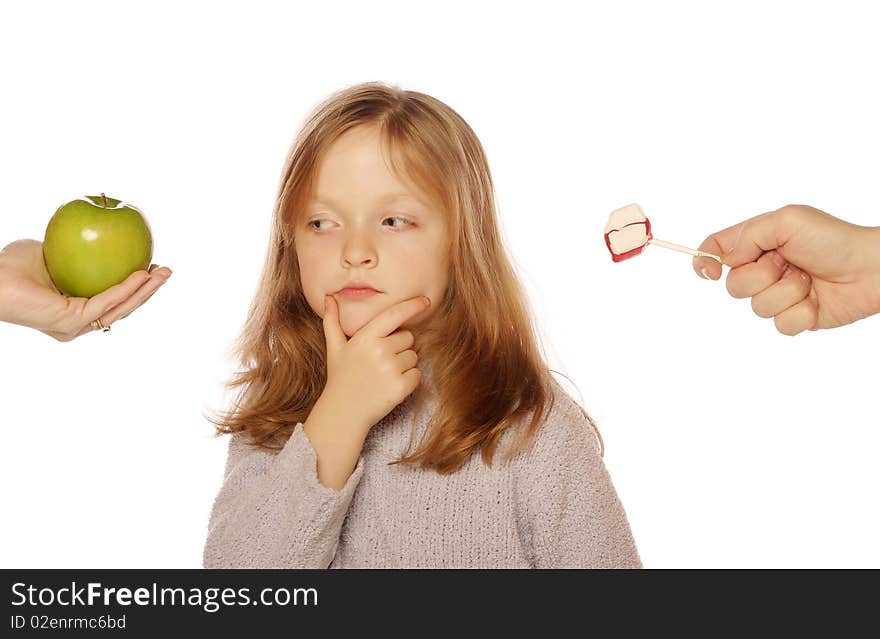 Young Girl Choosing Between An Apple And Candy