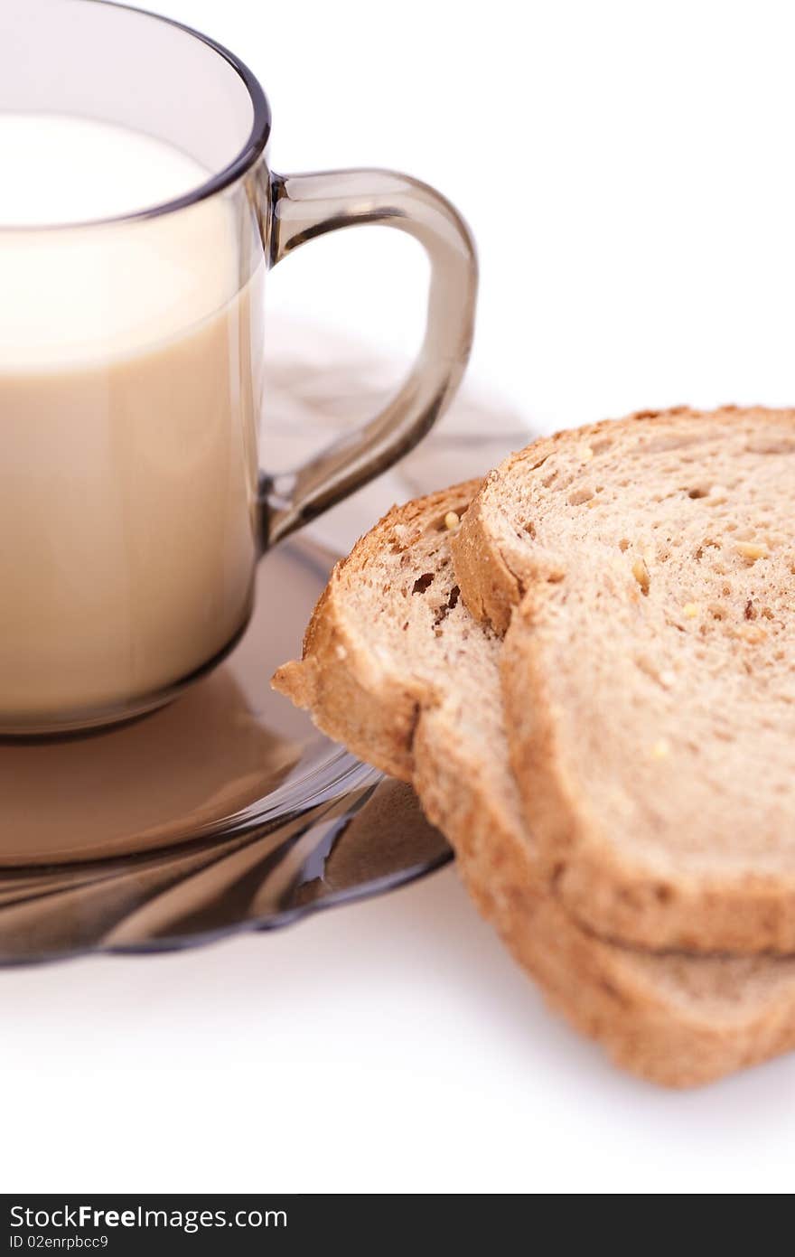 Bread and cup of milk on a white background (blurred)