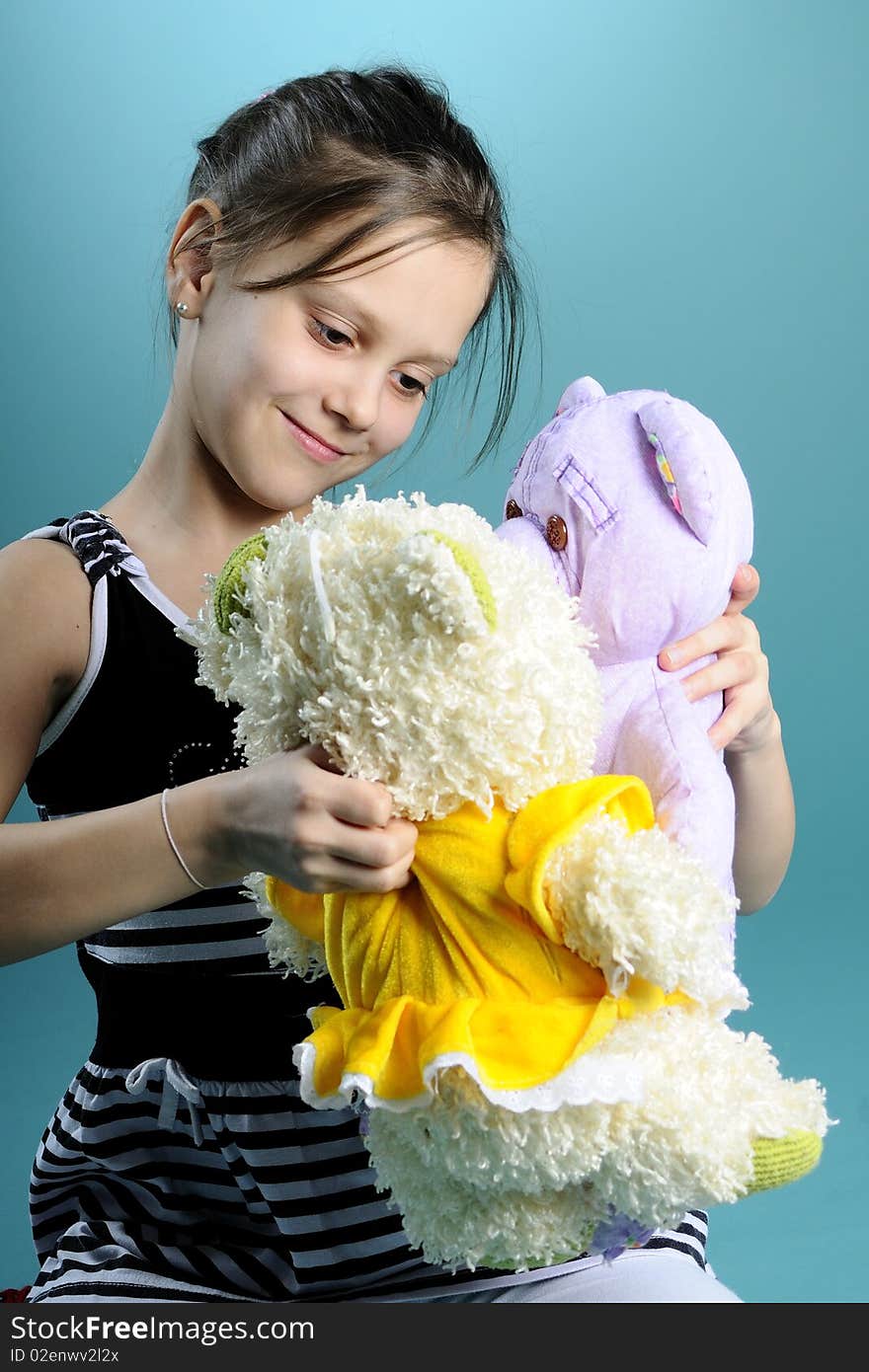 Little girl playing with teddy bear, turquoise background. Little girl playing with teddy bear, turquoise background