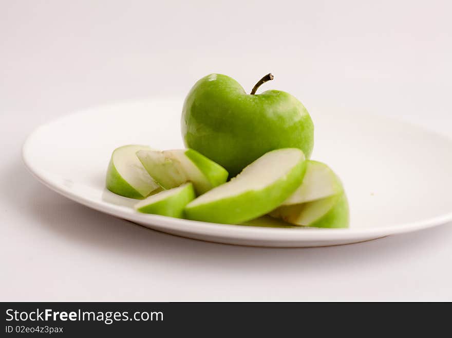 Sliced Apple on plate against white background