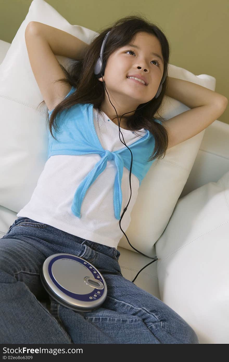 Girl lying in bed Listening to Music on CD Player, close up