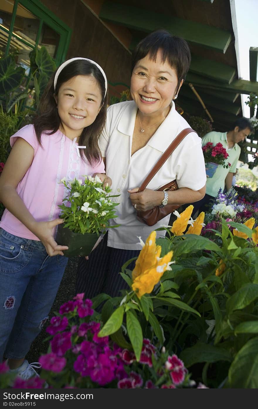 Grandmother And Granddaughter Holding Plant