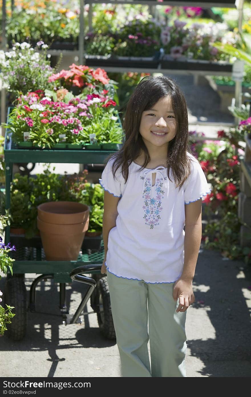 Young girl standing in plant nursery, portrait