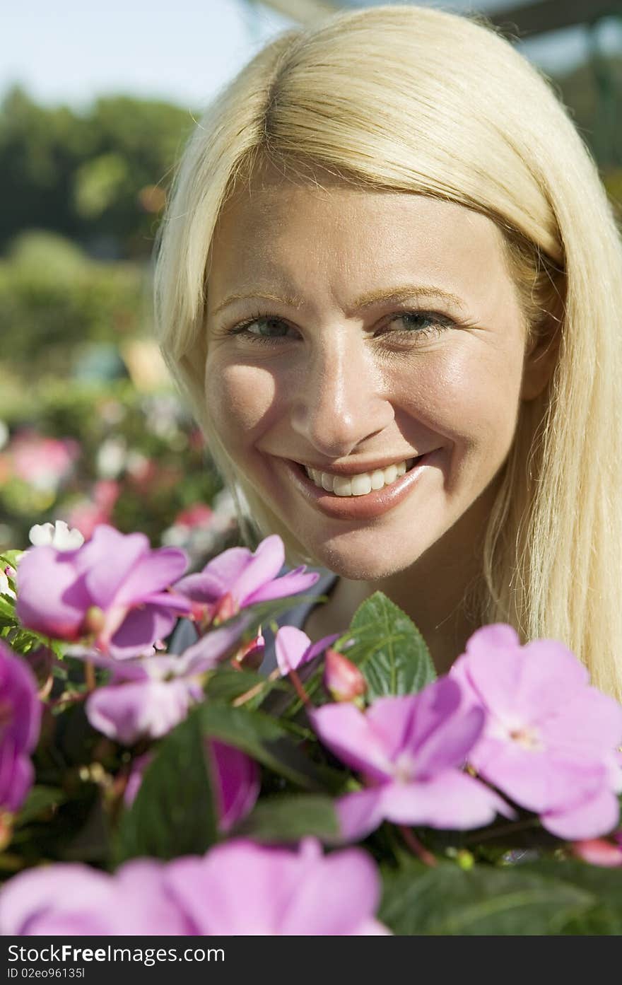 Woman Holding Flowers in plant nursery, portrait