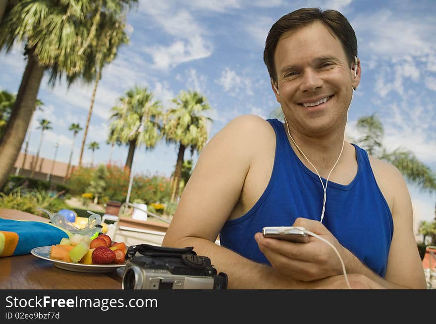 Man Listening to MP3 Player outdoors, portrait.