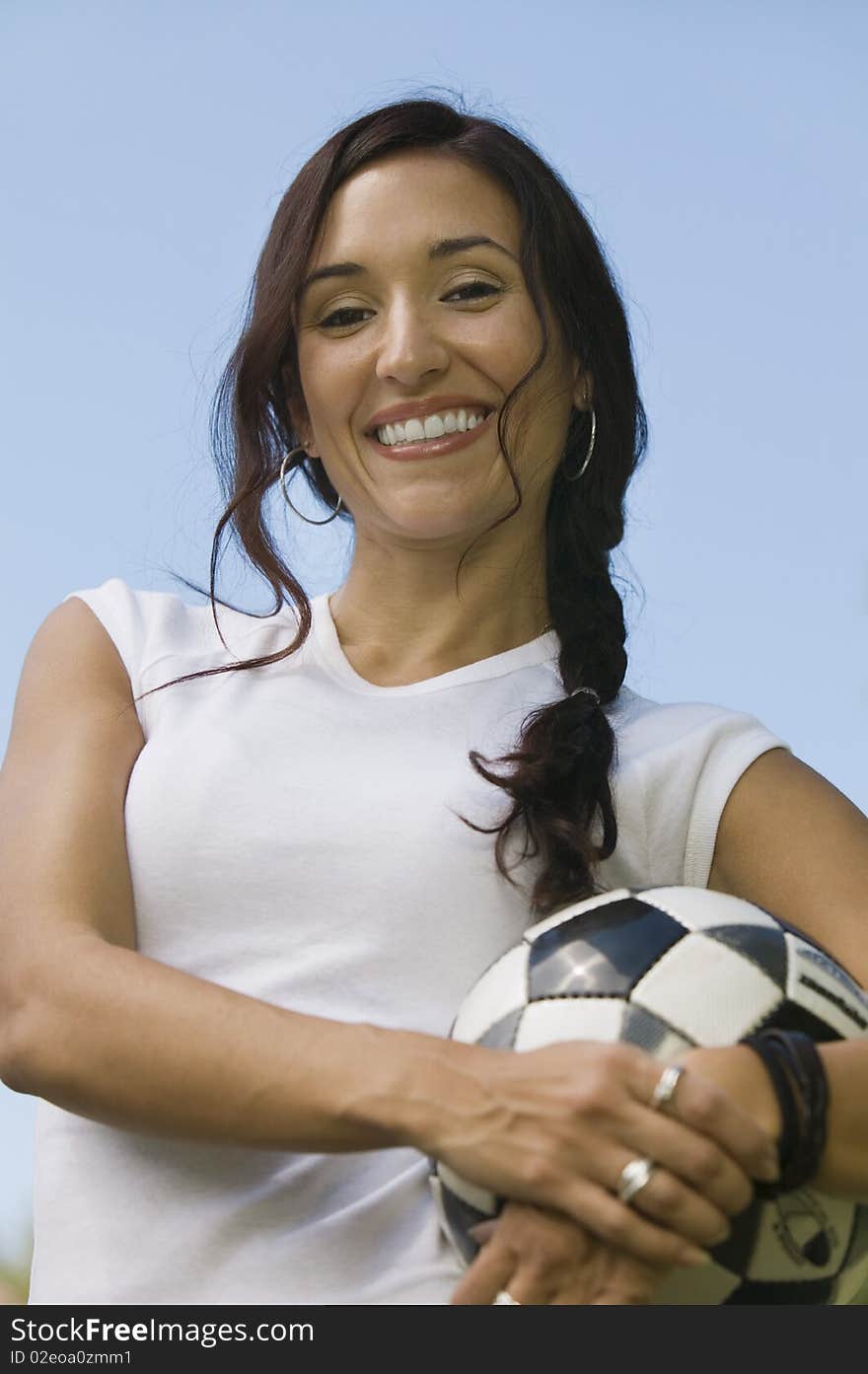 Woman Holding Soccer Ball, low angle portrait.