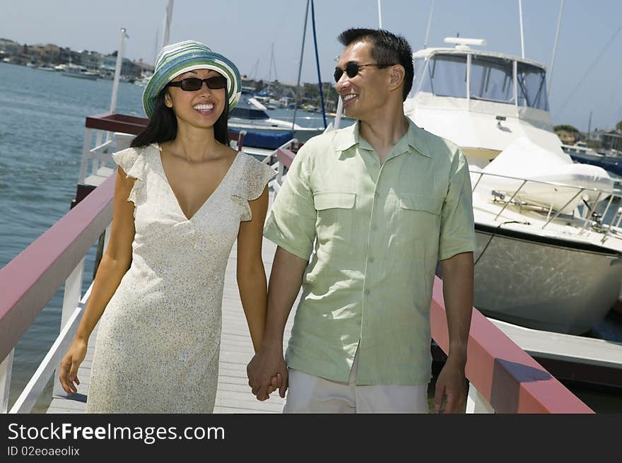 Asian ethnic Couple holding hands on docks