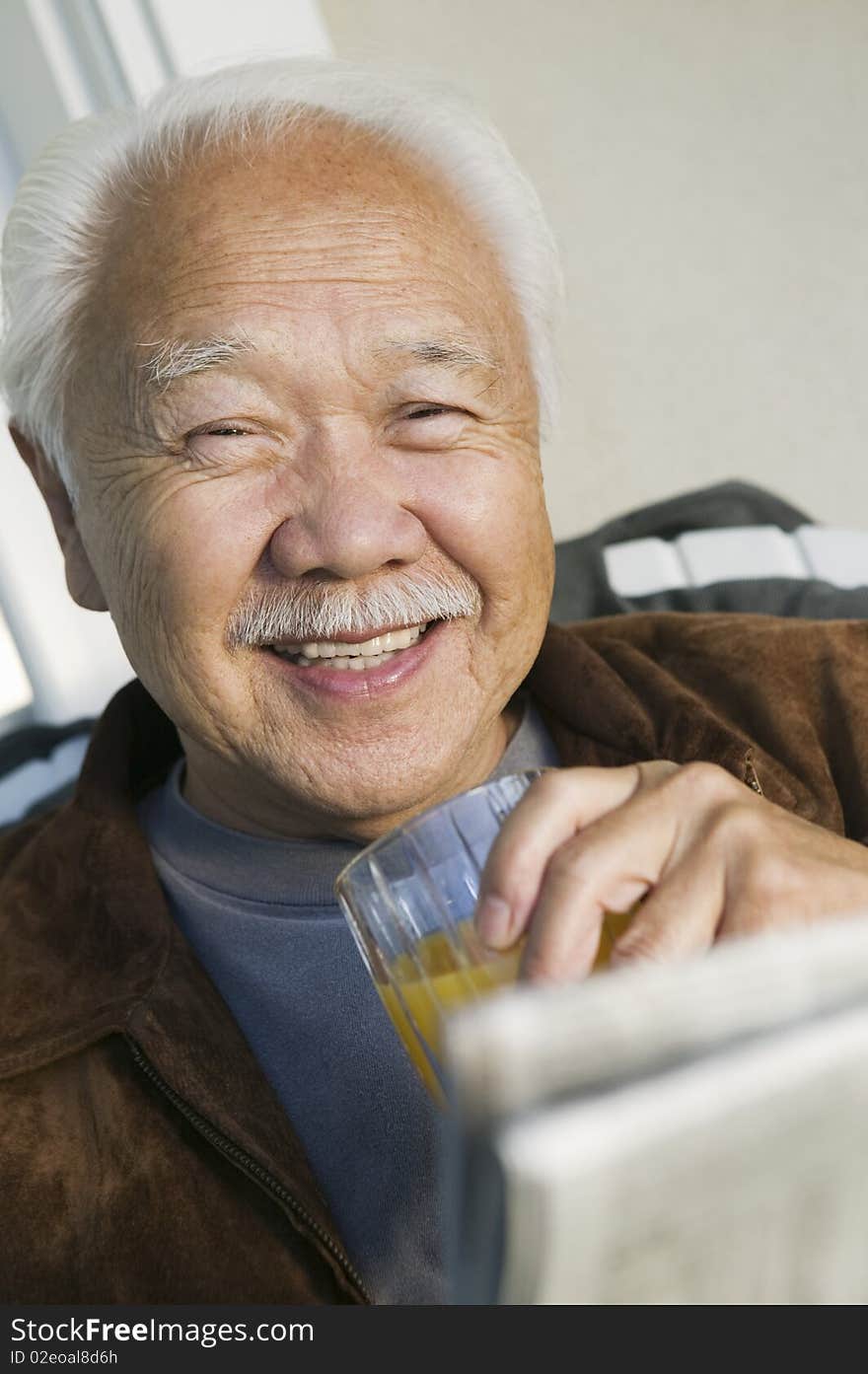 Man drinking orange juice, (portrait)