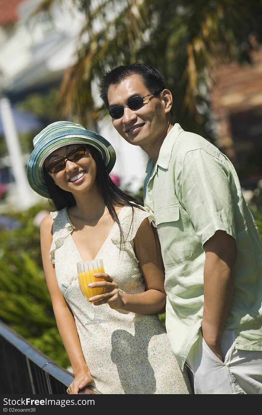 Couple with orange juice, outdoors, (portrait)