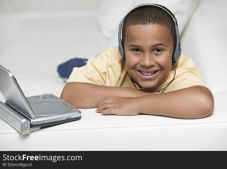 Boy on sofa Watching movie on Portable DVD Player, portrait. Boy on sofa Watching movie on Portable DVD Player, portrait