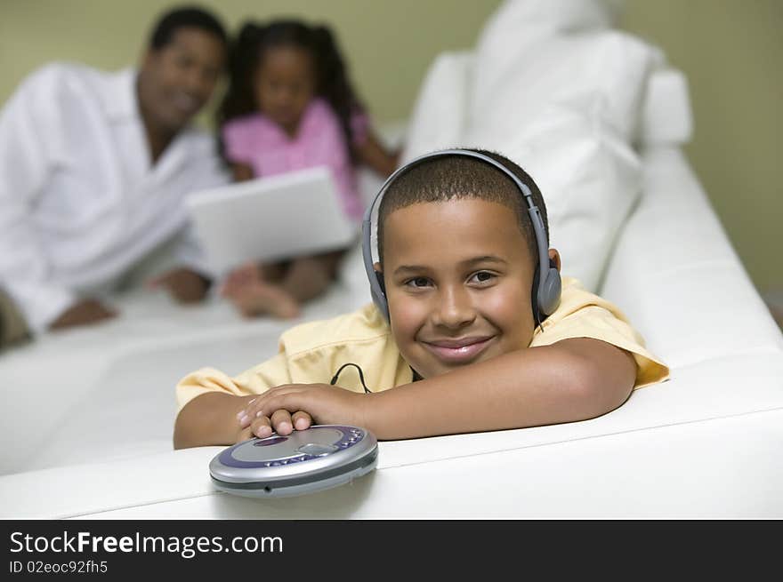 Boy Listening to music, father and sister on sofa