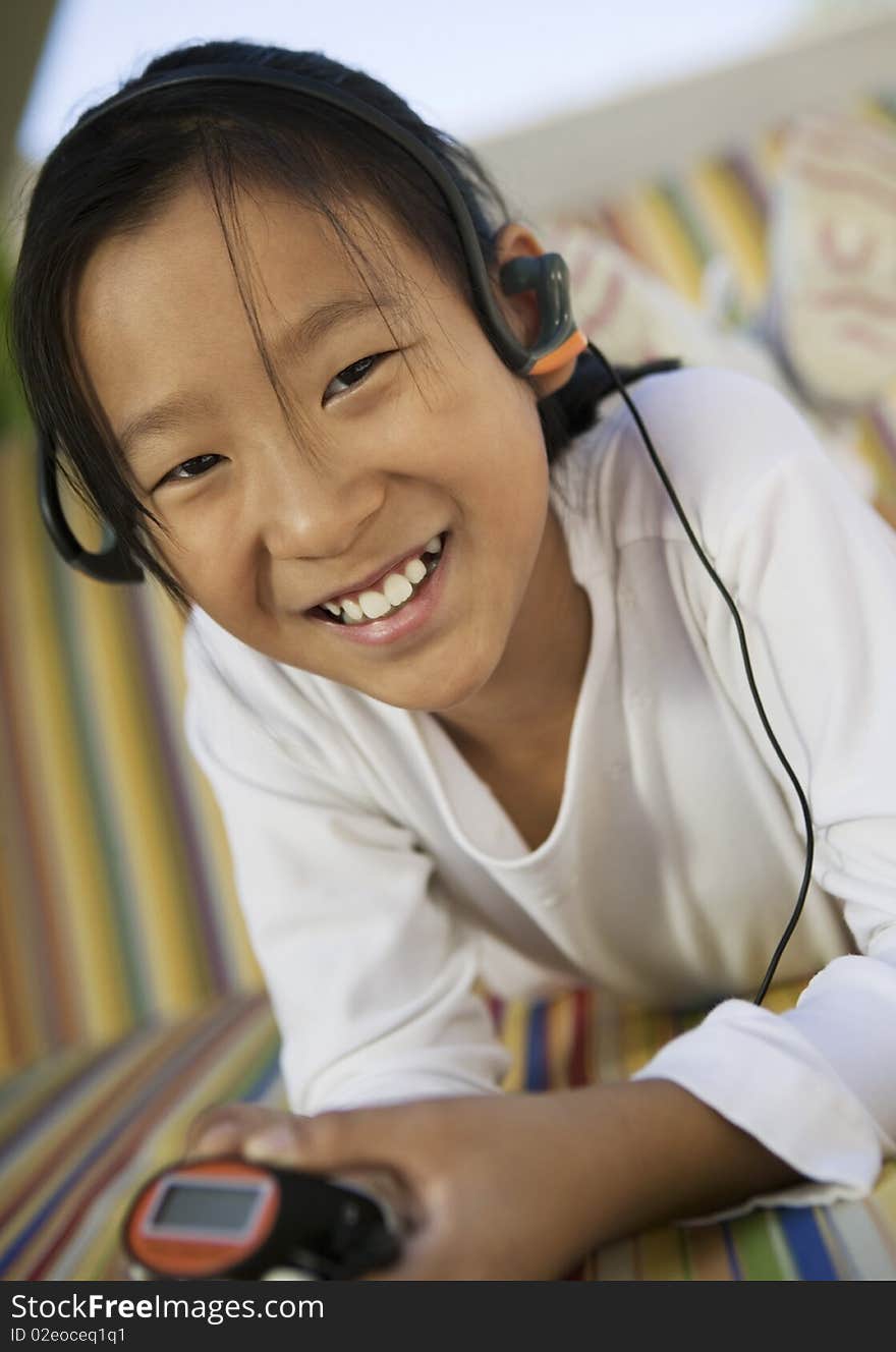 Girl sitting on sofa Listening to MP3 Player