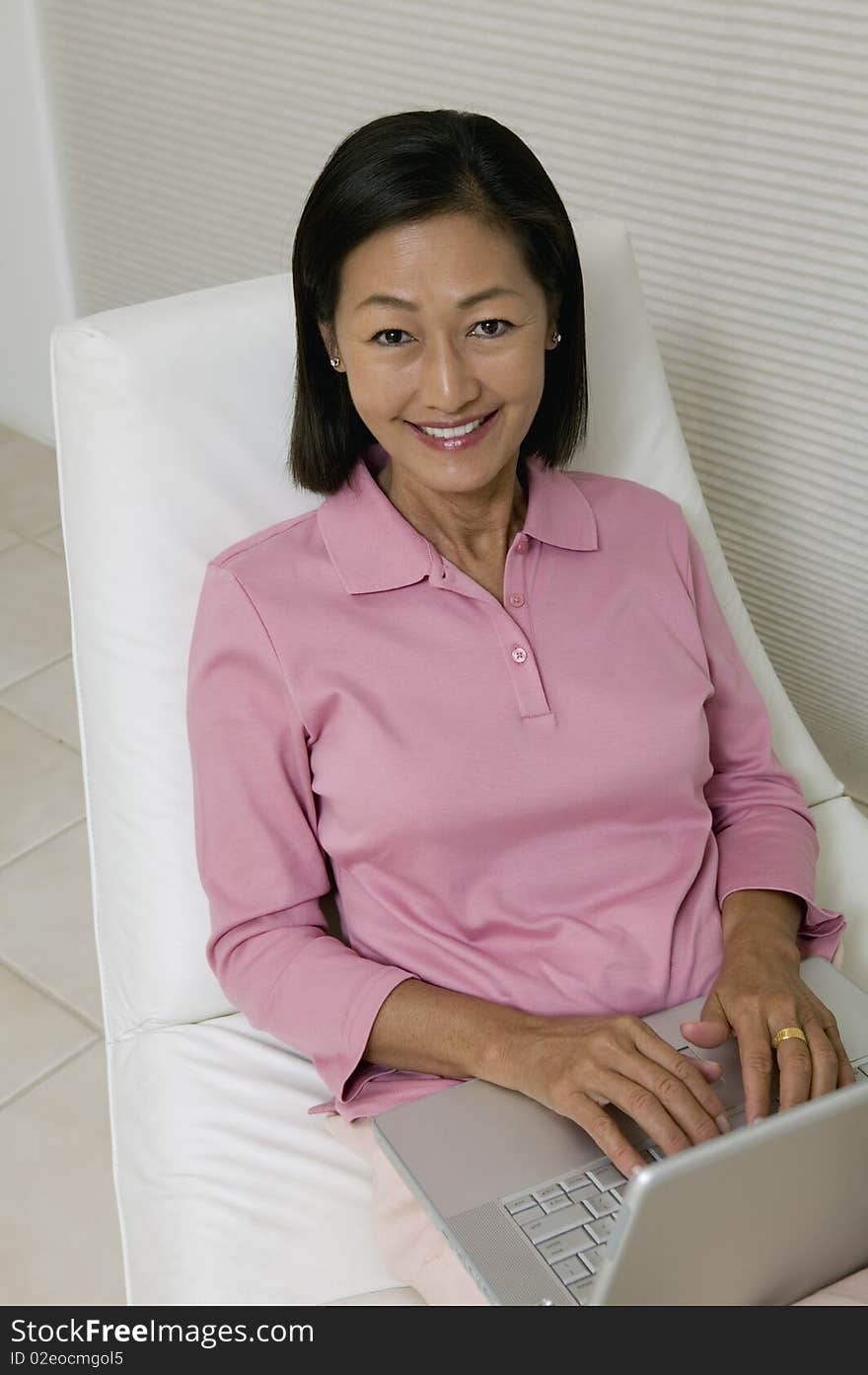 Woman in Chair Using Laptop, portrait, high angle view