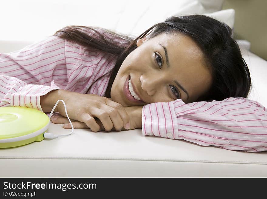 Woman Lying on sofa by Portable CD Player, portrait. Woman Lying on sofa by Portable CD Player, portrait