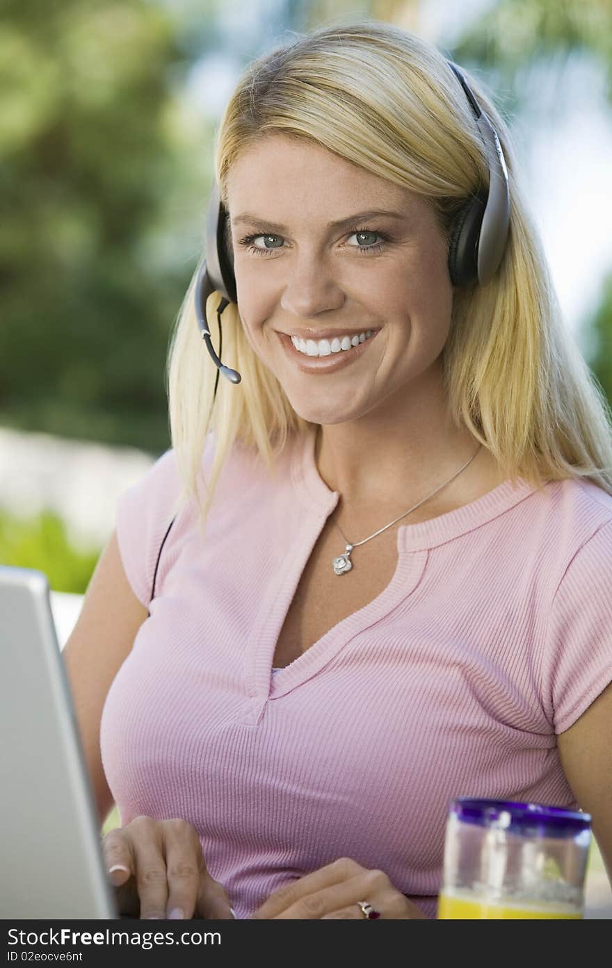 Woman Using Laptop and Headset