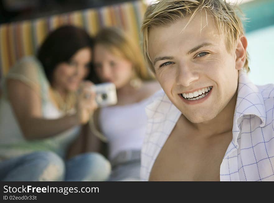 Young man sitting on patio smiling, portrait