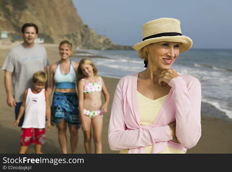 Grandmother at Beach with Family in background