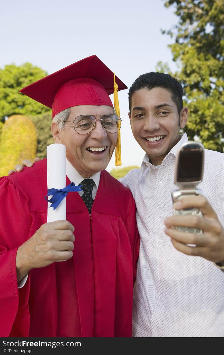 Senior Graduate and son taking picture with cell