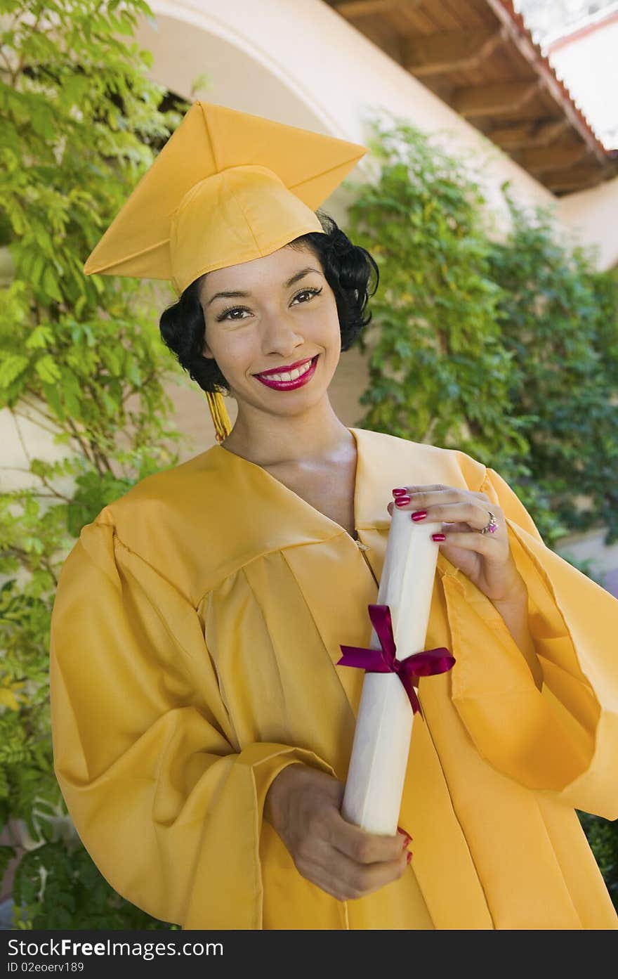 Graduate holding diploma outside