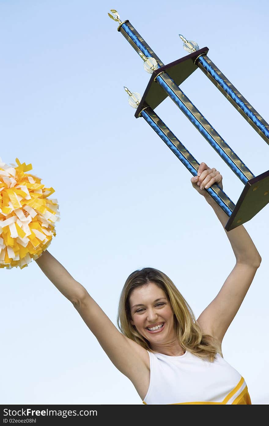 Smiling Cheerleader Holding Trophy