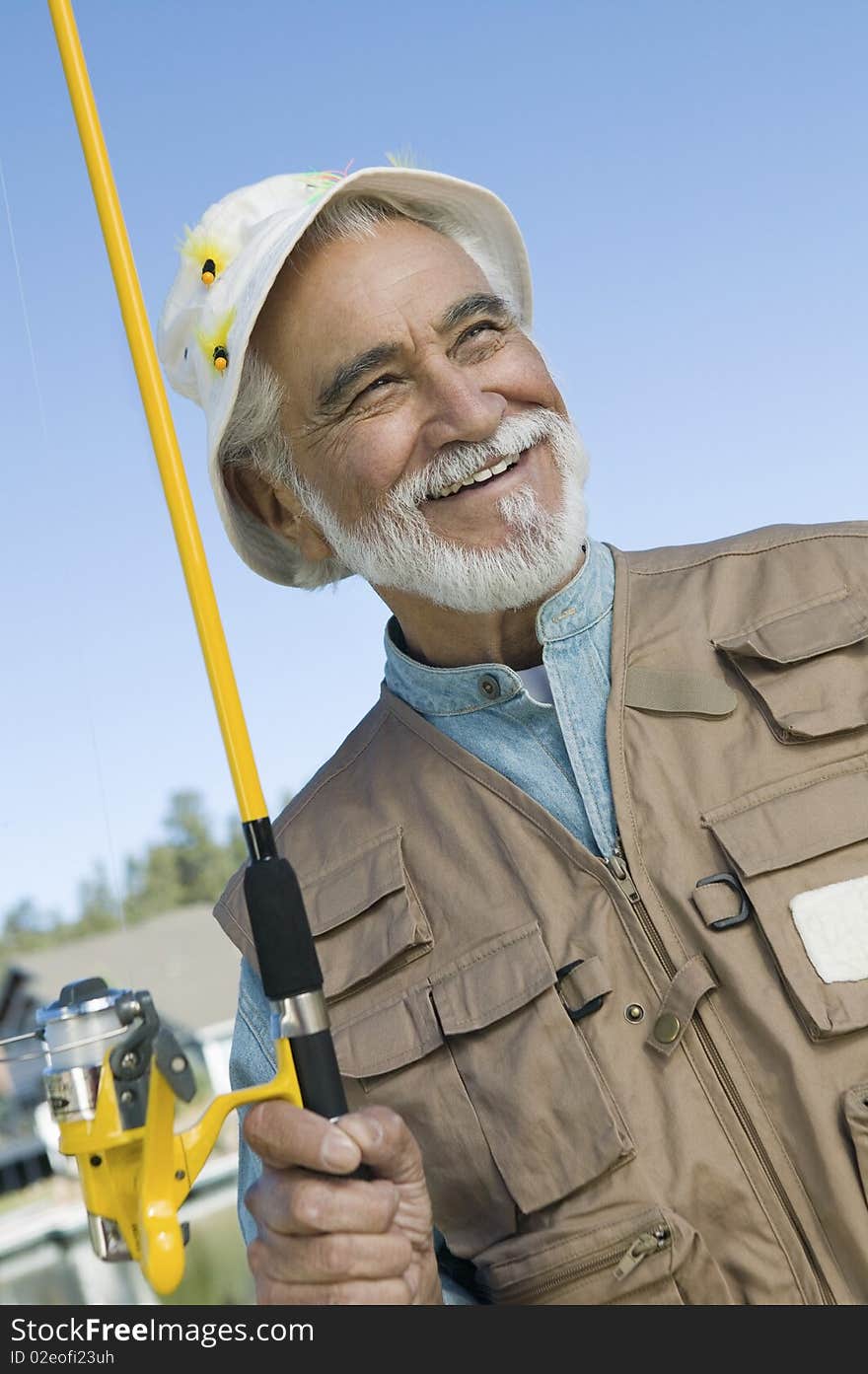 Middle-aged fisherman holding fishing rod outdoors. Middle-aged fisherman holding fishing rod outdoors