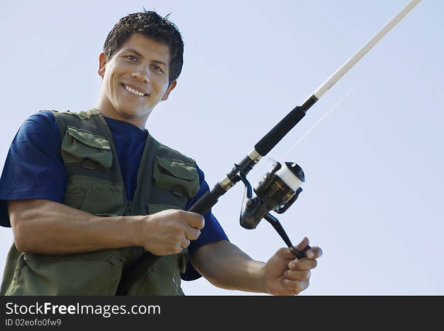 Man fly fishing, (portrait), (low angle view)