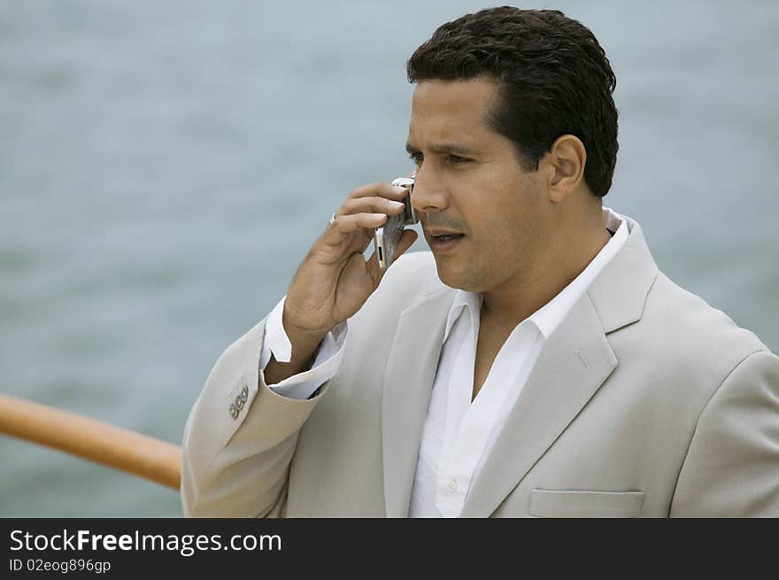 Well dressed Man talking on mobile phone on boat