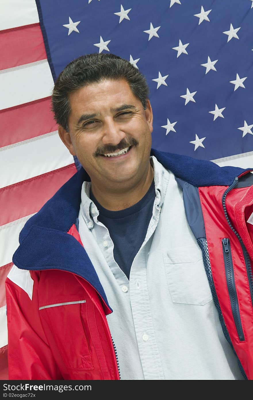 Man standing in front of American flag, (portrait)