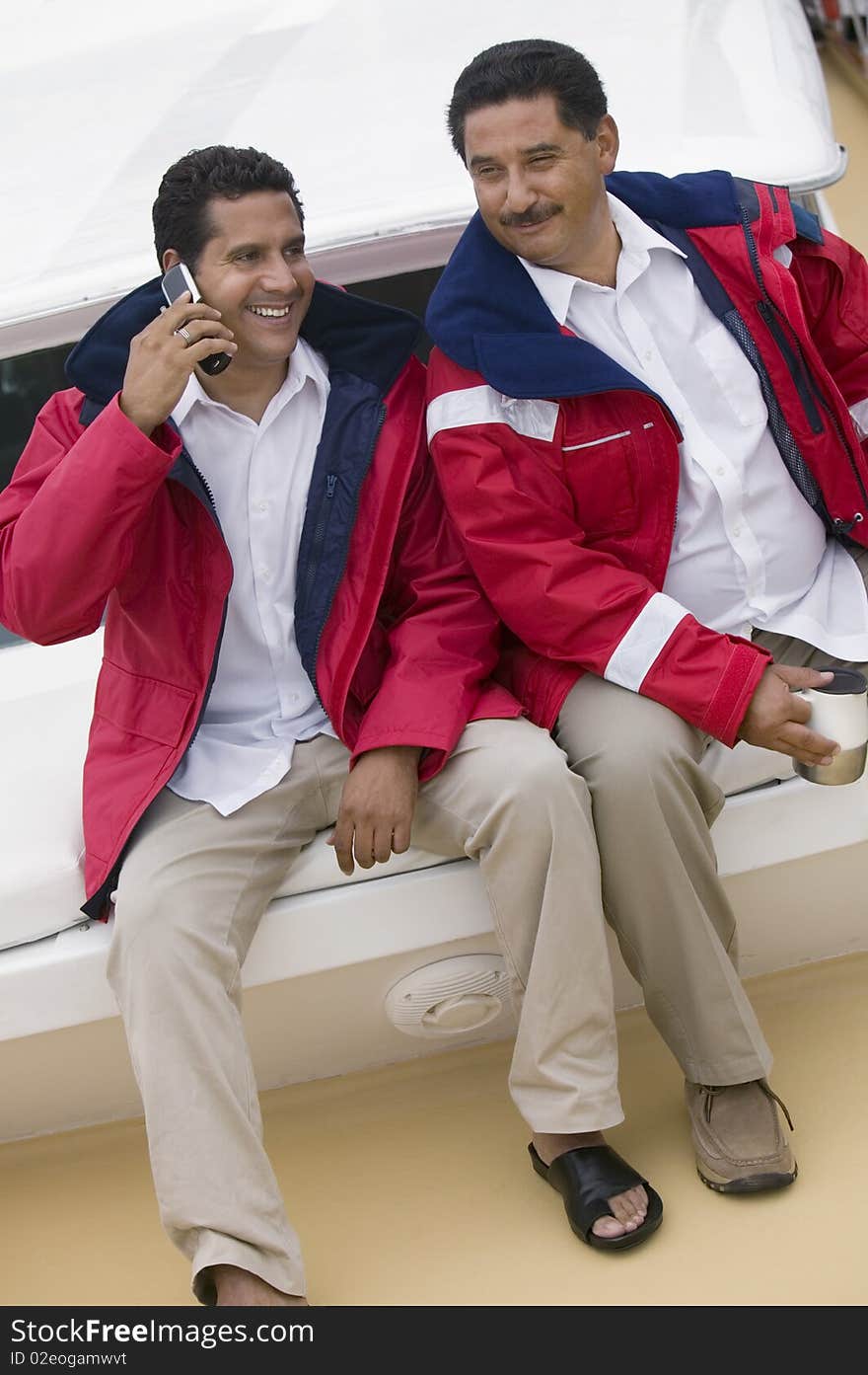 Two men relaxing on yacht, (elevated view)