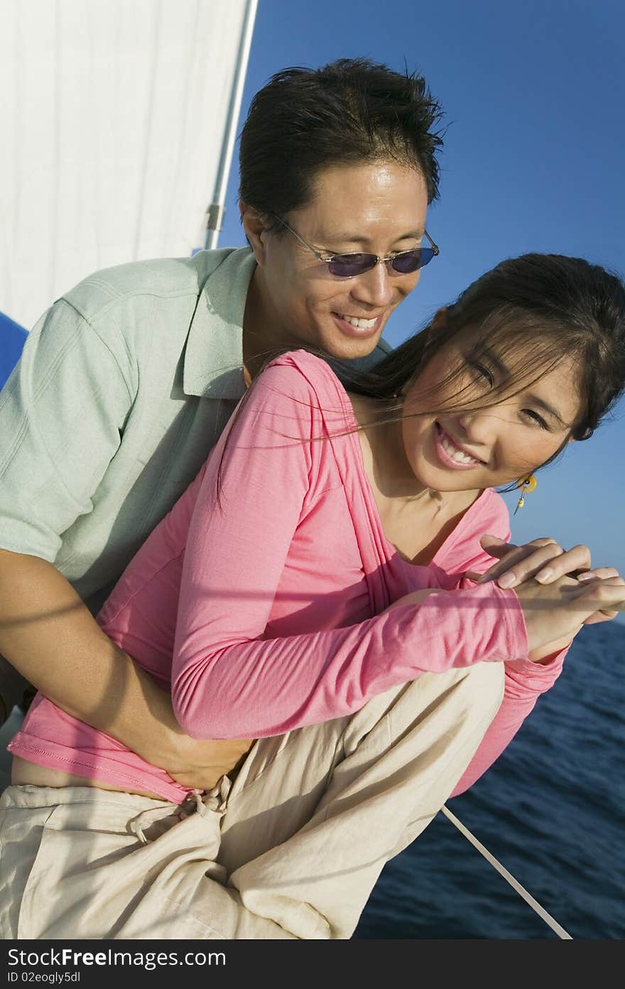 Asian ethnic Couple relaxing on yacht