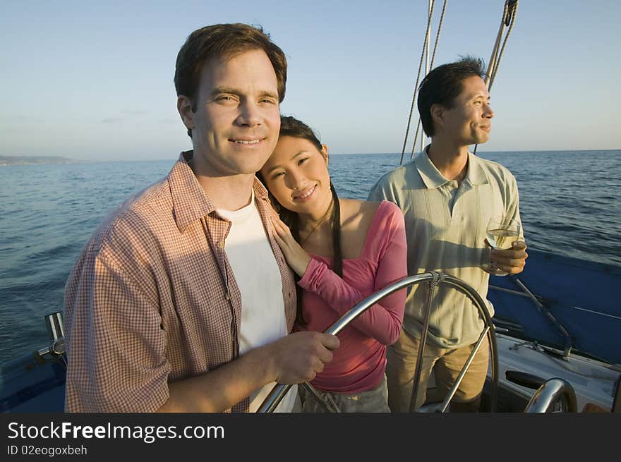 Couple with friend relaxing on yacht, (portrait)