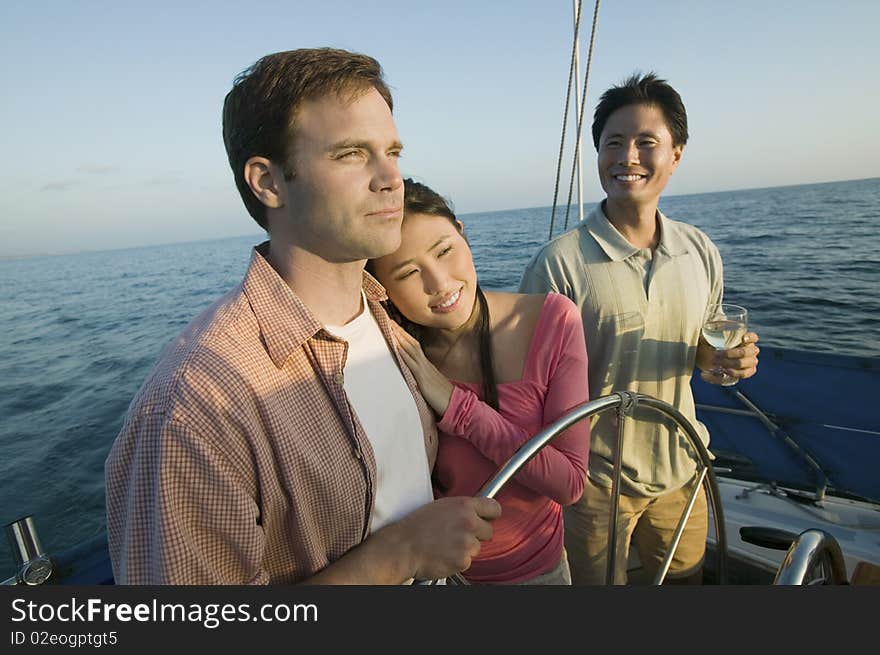 Couple with friend at steering on yacht. Couple with friend at steering on yacht