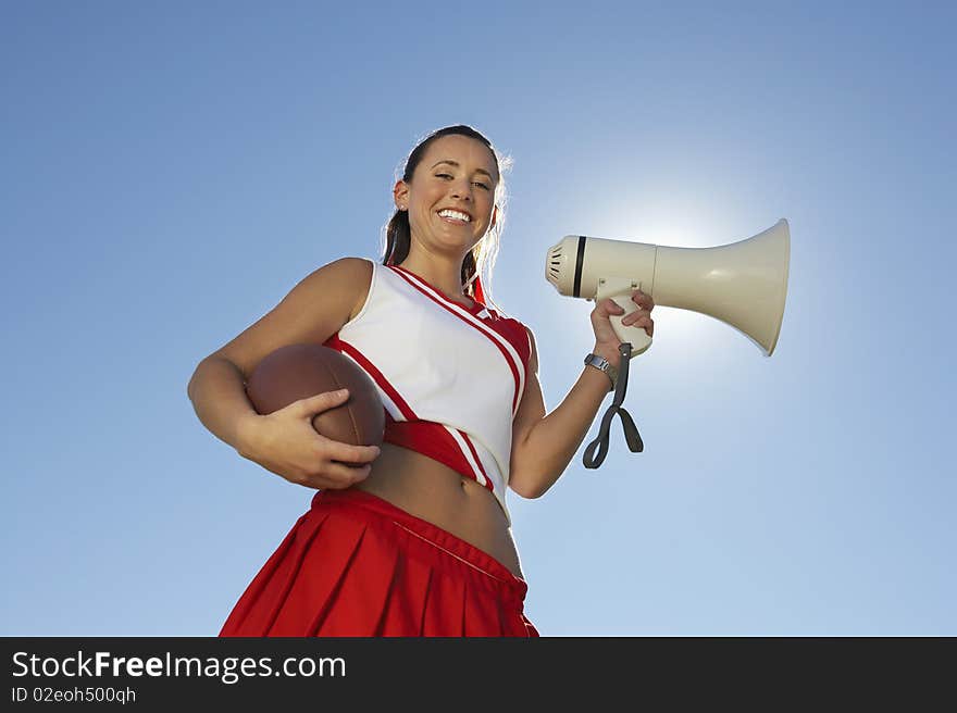 Cheerleader Holding Football And Megaphone