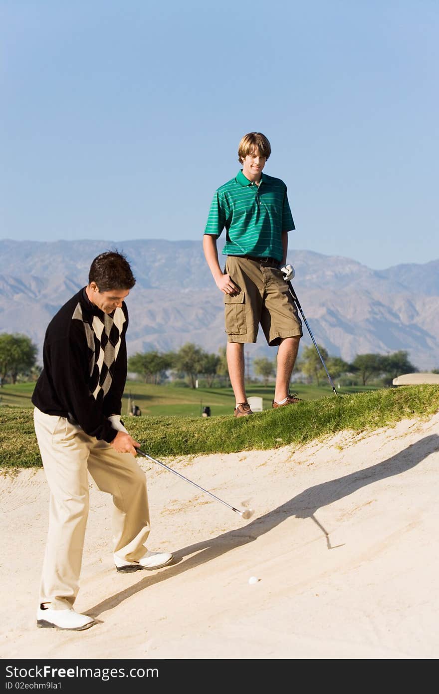 Golfer hitting ball from sand trap