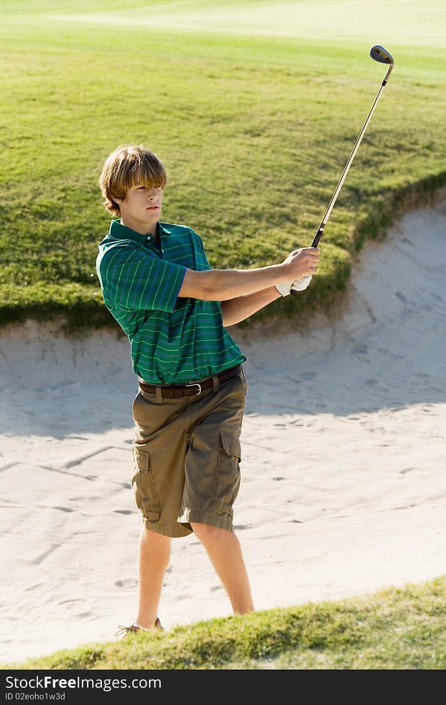 Golfer hitting ball from sand trap