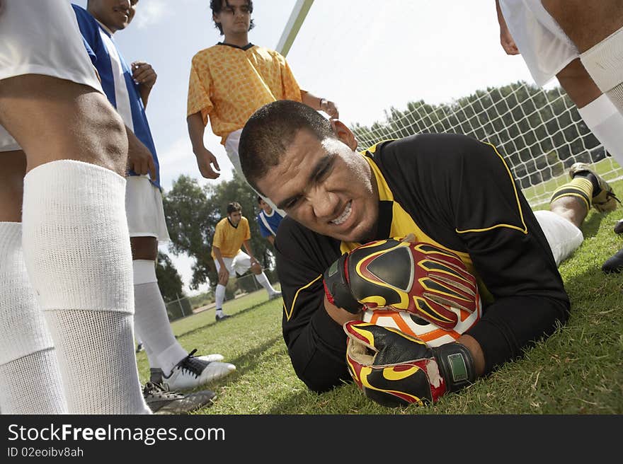 Goalkeeper on ground holding soccer ball